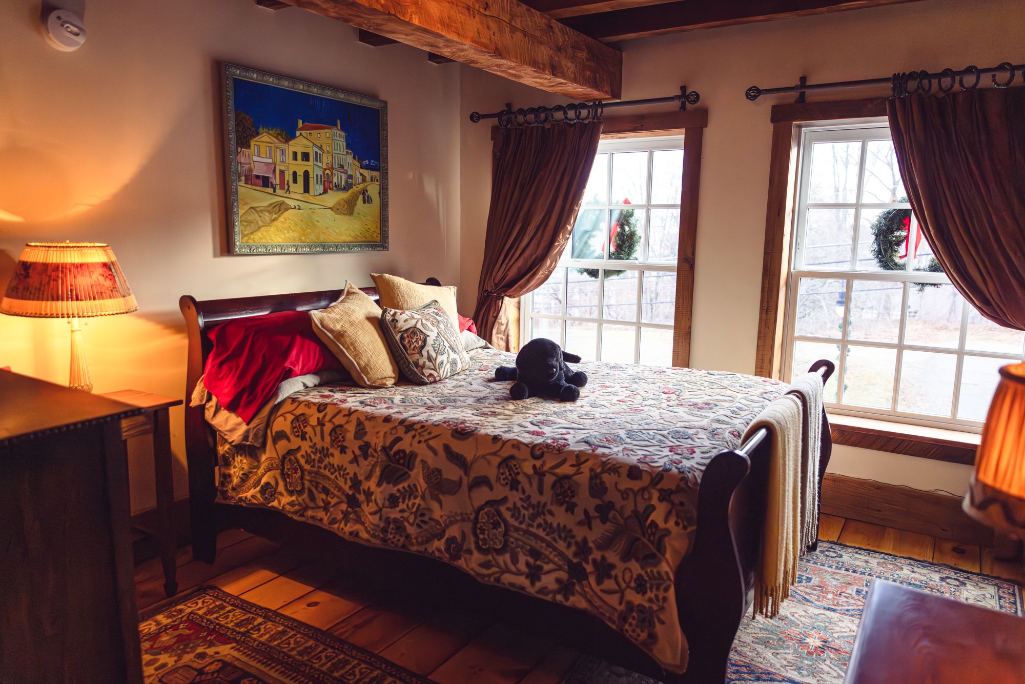 A bedroom with original beams and a sleigh bed